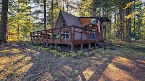 A cabin with a wooden deck, a staircase, and a view of the forest. - Serene Washington Escape w/ Deck & Mountain Views! (Packwood)