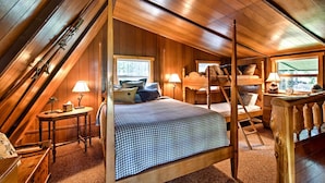A cozy attic bedroom with a four-poster bed, wooden walls, and a sloped ceiling. - Serene Washington Escape w/ Deck & Mountain Views! (Packwood)