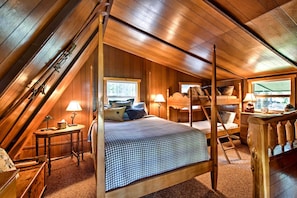 A cozy attic bedroom with a four-poster bed, wooden walls, and a sloped ceiling. - Serene Washington Escape w/ Deck & Mountain Views! (Packwood)