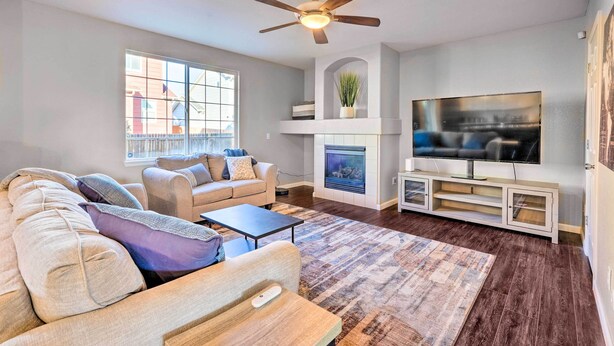 A living room with a sofa set, a coffee table, a fireplace, a television, and a ceiling fan. - Spacious Springs Home + Patio ~ 10 Mi to Dtwn (Colorado Springs)