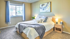 A bedroom with a bed, a nightstand, a ceiling fan, a window with curtains, and a painting on the wall. - Spacious Springs Home + Patio ~ 10 Mi to Dtwn (Colorado Springs)
