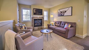A living room with a fireplace, a sofa, a chair, and a coffee table. - River Street Roost - 12 Miles to Sun Valley Resort (Hailey)