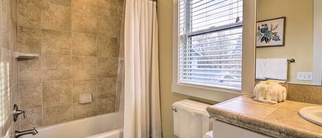 A bathroom with a bathtub, toilet, and sink.