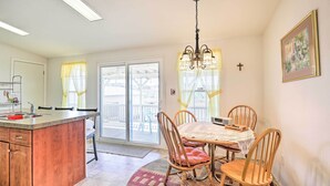 A kitchen with a central island, wooden chairs, a chandelier, and a dining table with a white tablecloth. - Quiet Tombstone Retreat ~ 3 Mi to Historic Dtwn! (Tombstone)