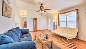 A living room with a ceiling fan, a sofa, a coffee table, and a window with curtains. - Quiet Tombstone Retreat ~ 3 Mi to Historic Dtwn! (Tombstone)