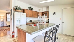 A modern kitchen with a central island, wooden cabinets, and a built-in water dispenser. - Quiet Tombstone Retreat ~ 3 Mi to Historic Dtwn! (Tombstone)