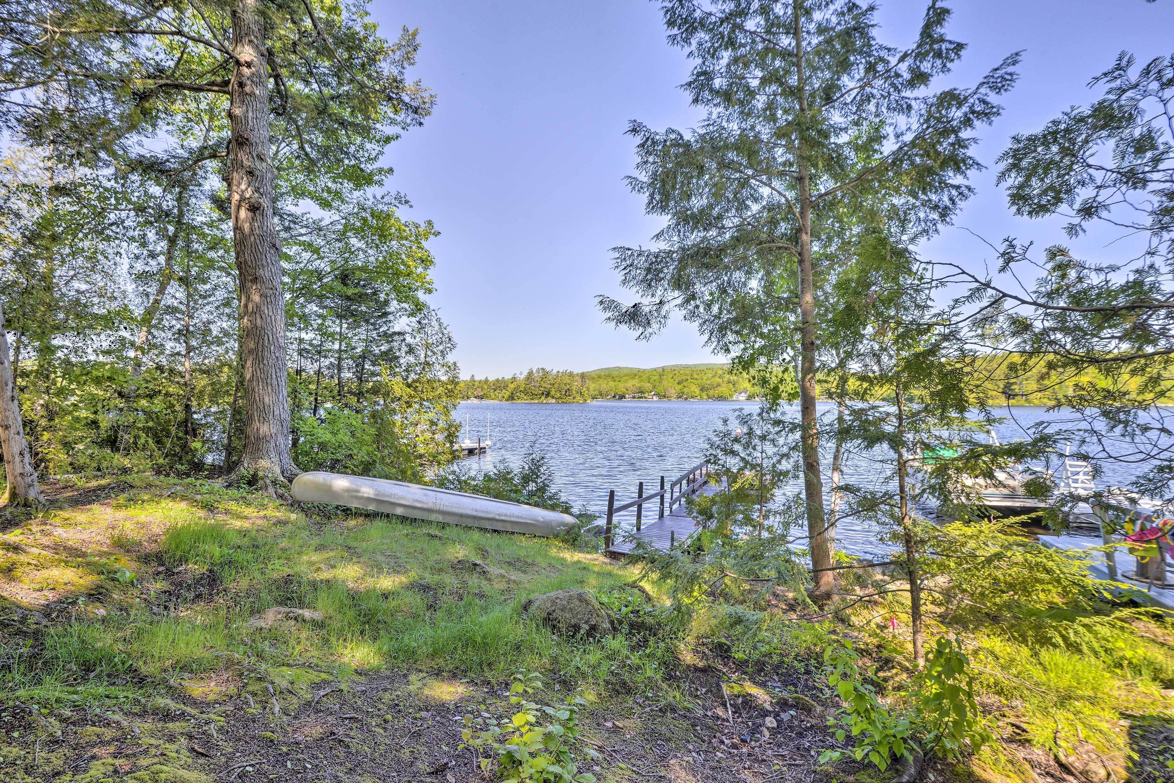 A serene lakeside setting with a dock and a canoe.