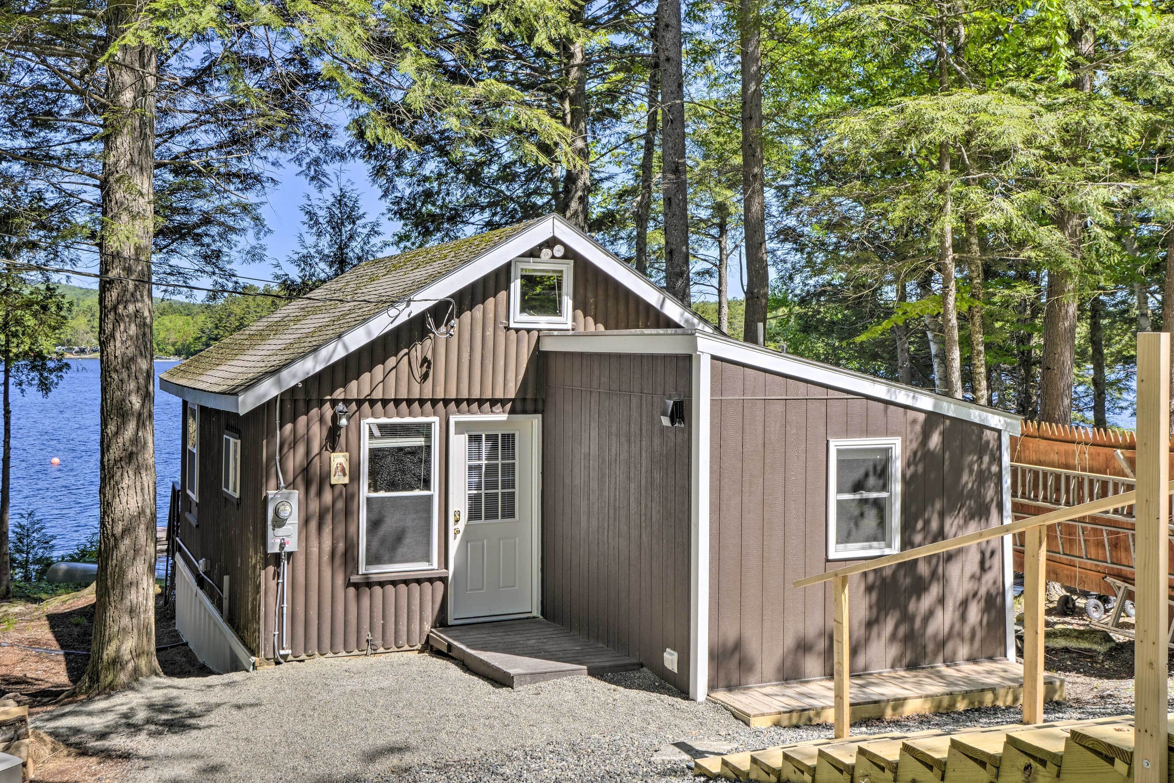 Une petite cabane avec une porte d’entrée, une fenêtre et un petit espace porche.