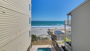 Vista de uma praia a partir de um edifício com piscina e terraço.