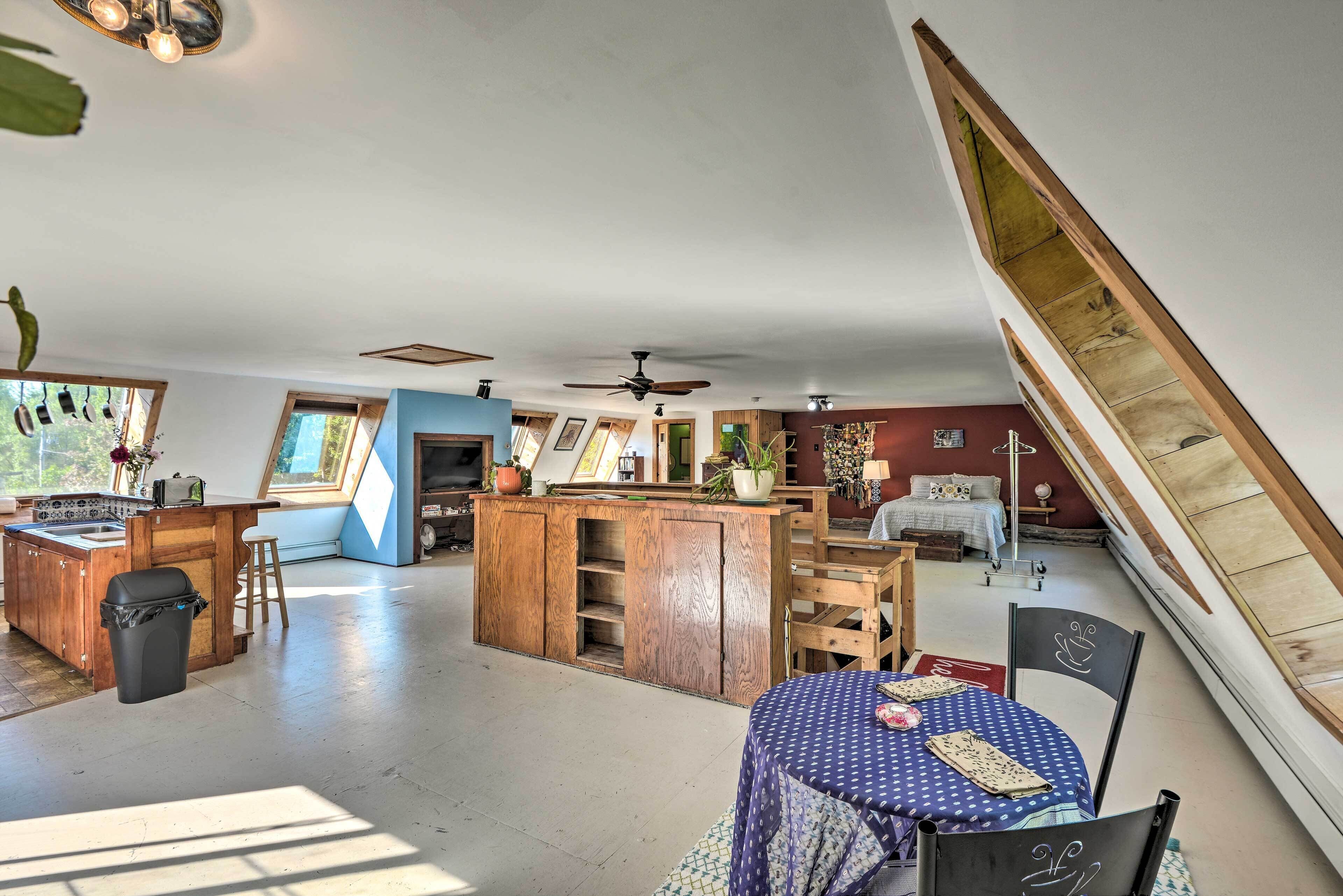 A spacious loft with a kitchen, dining area, and sleeping quarters.