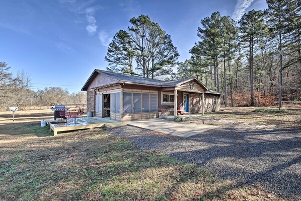 A rustic cabin with a large deck, a covered outdoor seating area, and a water wheel. - Secluded Boles Home Near River: Pets Welcome! (Boles)