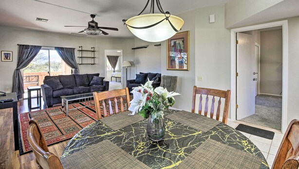A dining area with a round table, chairs, a vase with flowers, a ceiling fan, and a view of the outdoors. - Tranquil Green Valley Townhome w/ Mtn Views! (Green Valley)