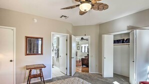 A bedroom with a bed, a ceiling fan, a small table, and a closet. - Tranquil Green Valley Townhome w/ Mtn Views! (Green Valley)
