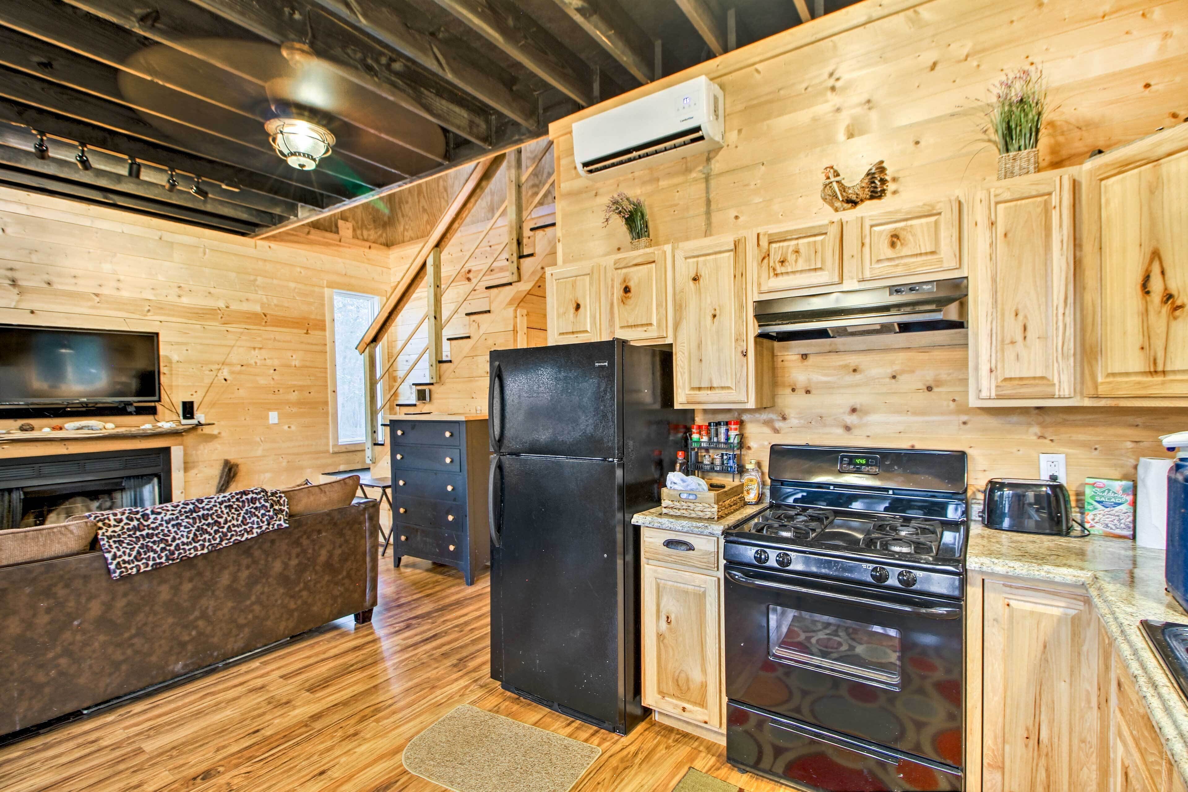 A wooden interior with a kitchen area featuring a refrigerator, stove, and wooden cabinets.
