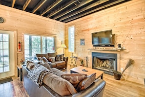 Cozy living room with a fireplace, flat-screen TV, and comfortable seating area.