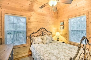 Cozy bedroom with a bed, ceiling fan, and bedside table, offering a simple and functional space for rest.