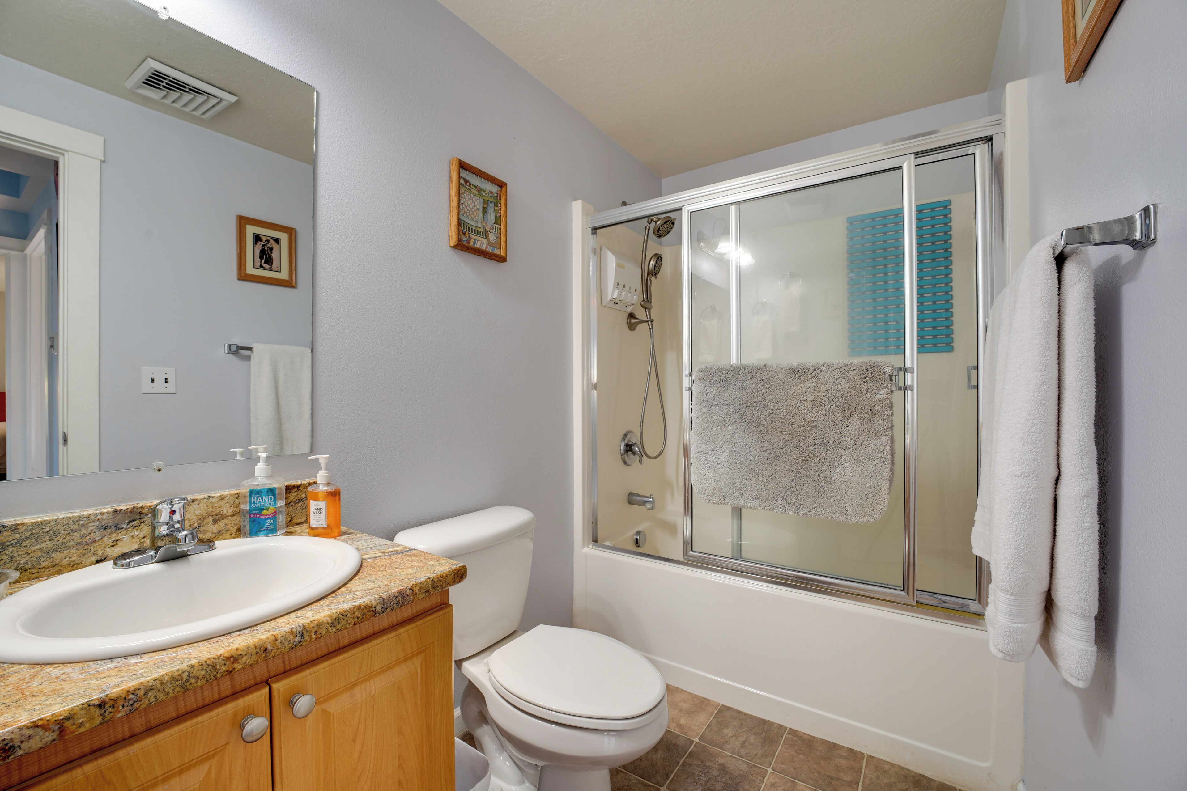 A bathroom with a sink, toilet, and glass-enclosed shower.