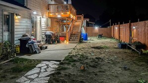A backyard with a wooden deck, a staircase, and a fenced area. - Springfield Apt w/ Deck + Central Location! (Springfield)