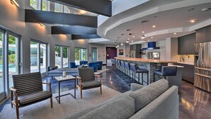 A spacious living area with a high ceiling, large windows, and a modern kitchen. - Southern Shores Retreat w/ Expansive Outdoor Space (Kitty Hawk)