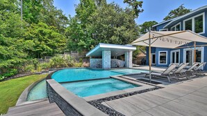 A swimming pool with a covered area, lounge chairs, and a stone-tiled deck. - Southern Shores Retreat w/ Expansive Outdoor Space (Kitty Hawk)