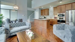 Une cuisine moderne avec des meubles en bois, des appareils en acier inoxydable et un îlot central.