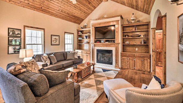 A cozy living room with a fireplace, wooden ceiling, and a large bookshelf. - Pet-friendly Abingdon Abode w/ Yard & Grill! (Abingdon)