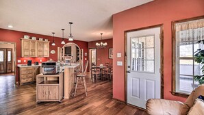 A spacious kitchen with wooden cabinets, a dining area with a table and chairs, and a leather sofa. - Pet-friendly Abingdon Abode w/ Yard & Grill! (Abingdon)