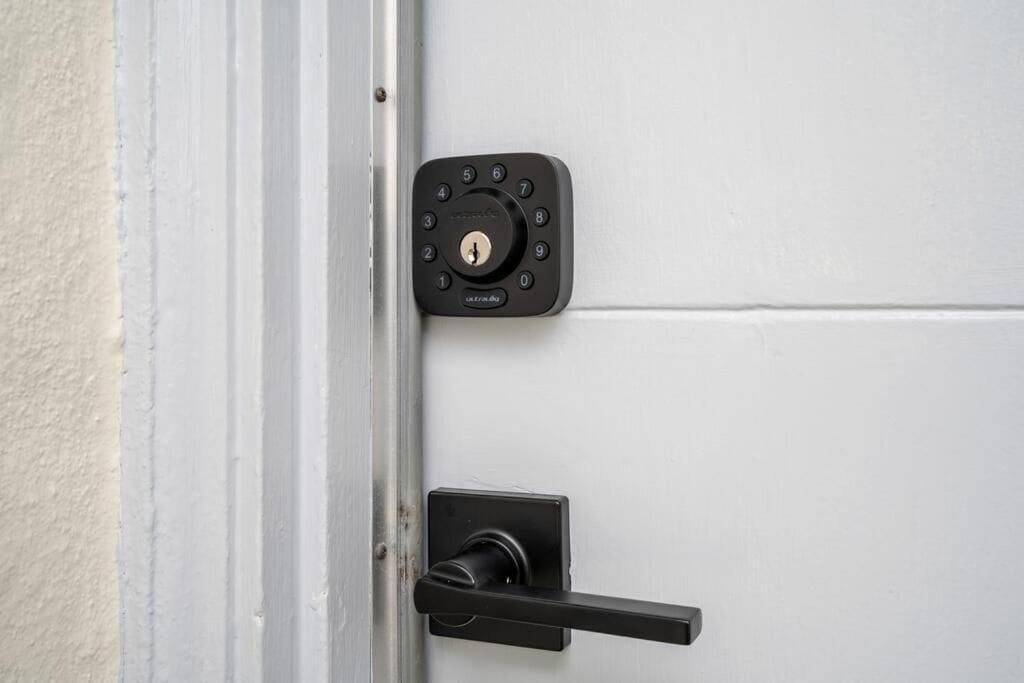 A door with a numeric keypad lock and a lever handle.
