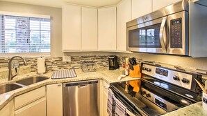 A modern kitchen with stainless steel appliances, a dishwasher, and a countertop with a toaster and coffee maker. - Pool & Hot Tub Access: Modern Palm Springs Condo (Palm Springs)