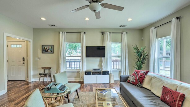 A living room with a ceiling fan, a flat-screen TV, a sofa, a coffee table, and a chair. - East Austin Hideaway ~ 4 Mi to Ladybird Lake! (Austin)