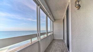 A corridor with large windows overlooking a beach, a wooden floor, and a textured wall. - Remodeled Redington Shores Gem on the Beach! (Redington Shores)