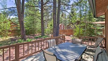 Enjoy a serene view from this elevated deck surrounded by tall trees.