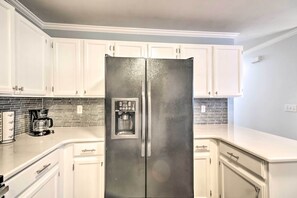 A kitchen with white cabinets, a stainless steel refrigerator, and a coffee maker. - Loveland Duplex w/ Large Yard: 2 Mi to Dtwn (Loveland)
