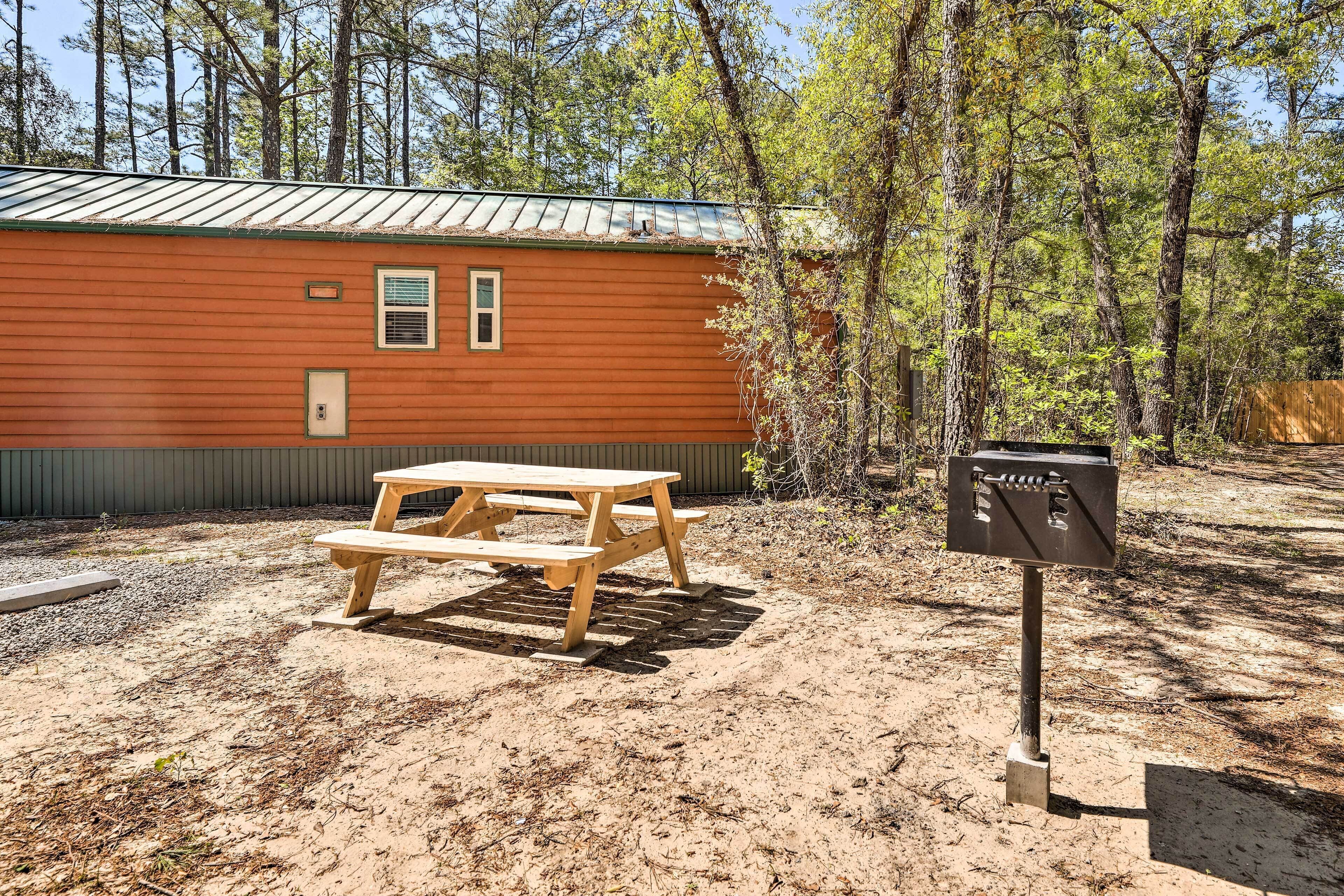 A rustic cabin with a picnic table and a mailbox.