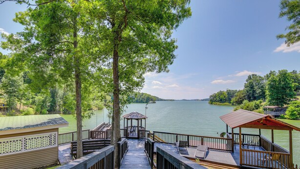 Une terrasse en bois menant à un belvédère d’où l’on peut admirer un lac.