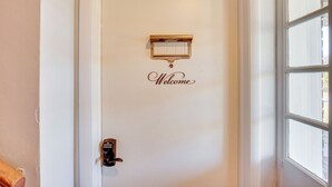 Eine Tür mit einem 'Welcome'-Schild und einem Schlüsselkartenleser.
