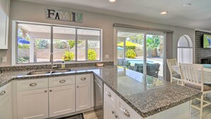 A kitchen with white cabinets, granite countertops, and a large window. - Pool & Putting Green: Scottsdale Family Escape (Scottsdale)