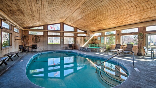 An indoor swimming pool with wooden walls and ceiling, surrounded by lounge chairs and a stone bench. - Southern Maine Retreat < 2 Mi to Wells Beach! (Wells)