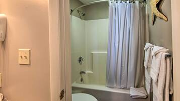 Un baño con ducha, inodoro y perchero para toallas.