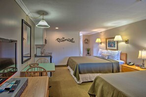 Een hotelkamer met twee bedden, een bureau, een televisie en een zithoek.