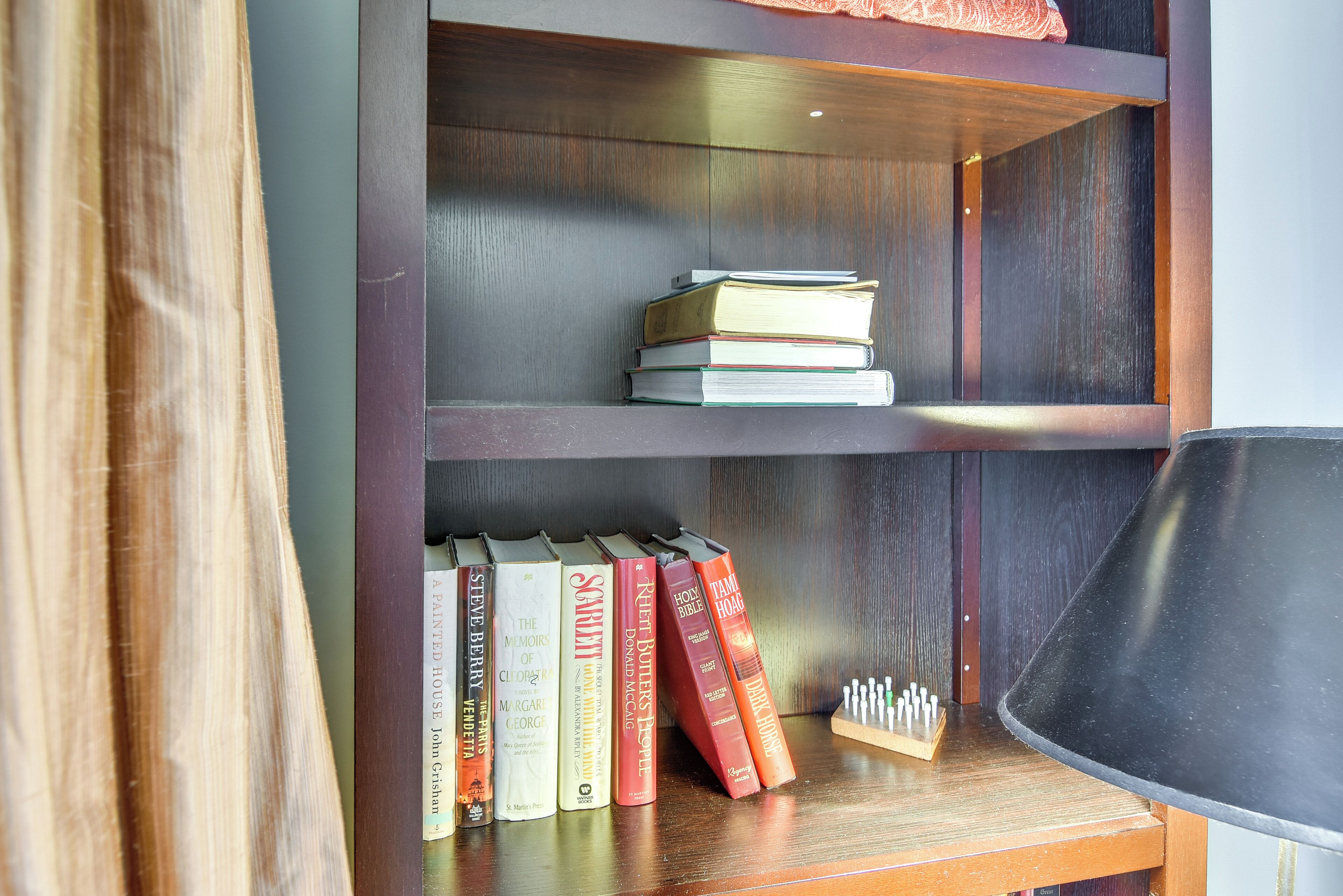 A bookshelf with books and a lamp.