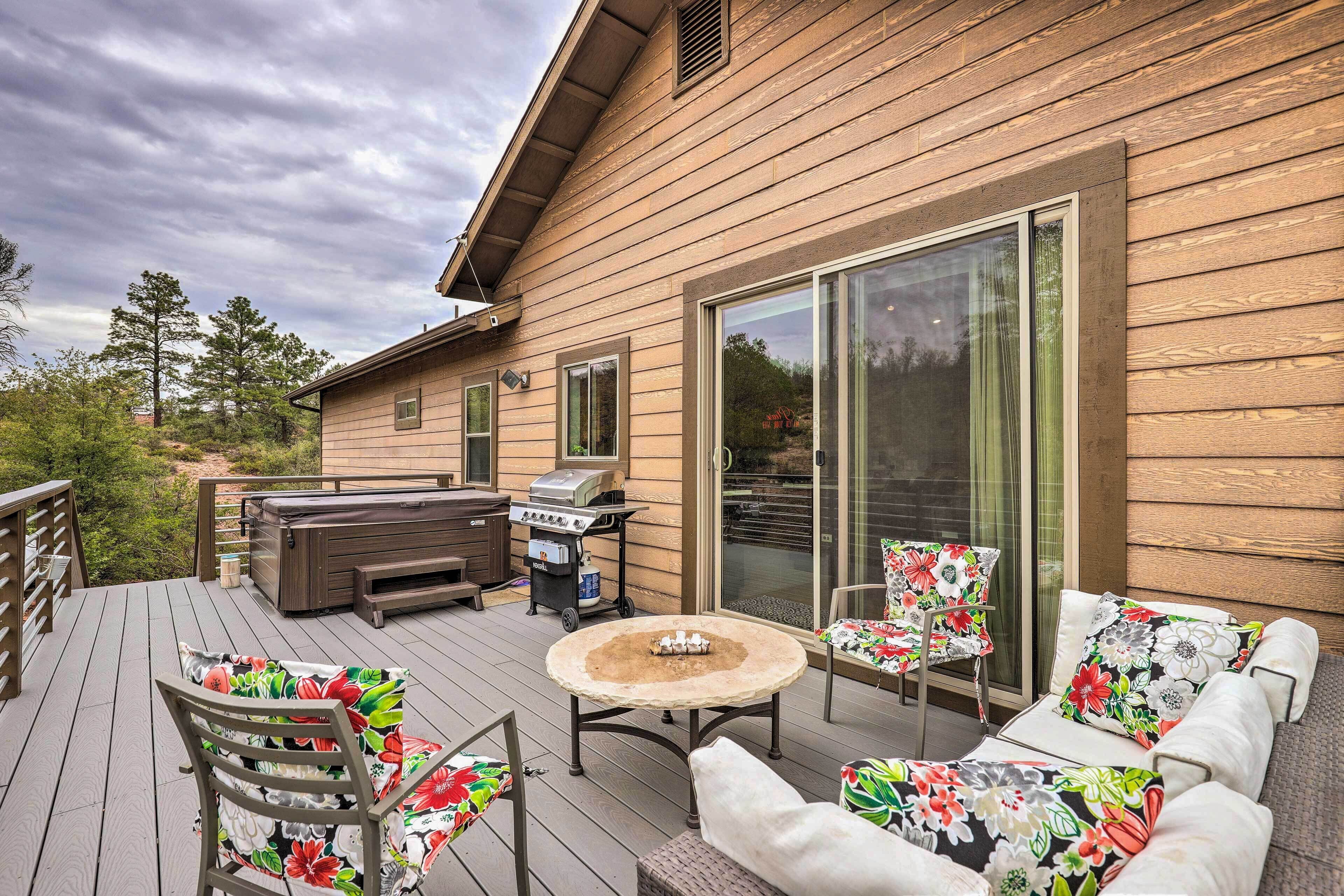 A wooden deck with outdoor furniture, a grill, and a hot tub.