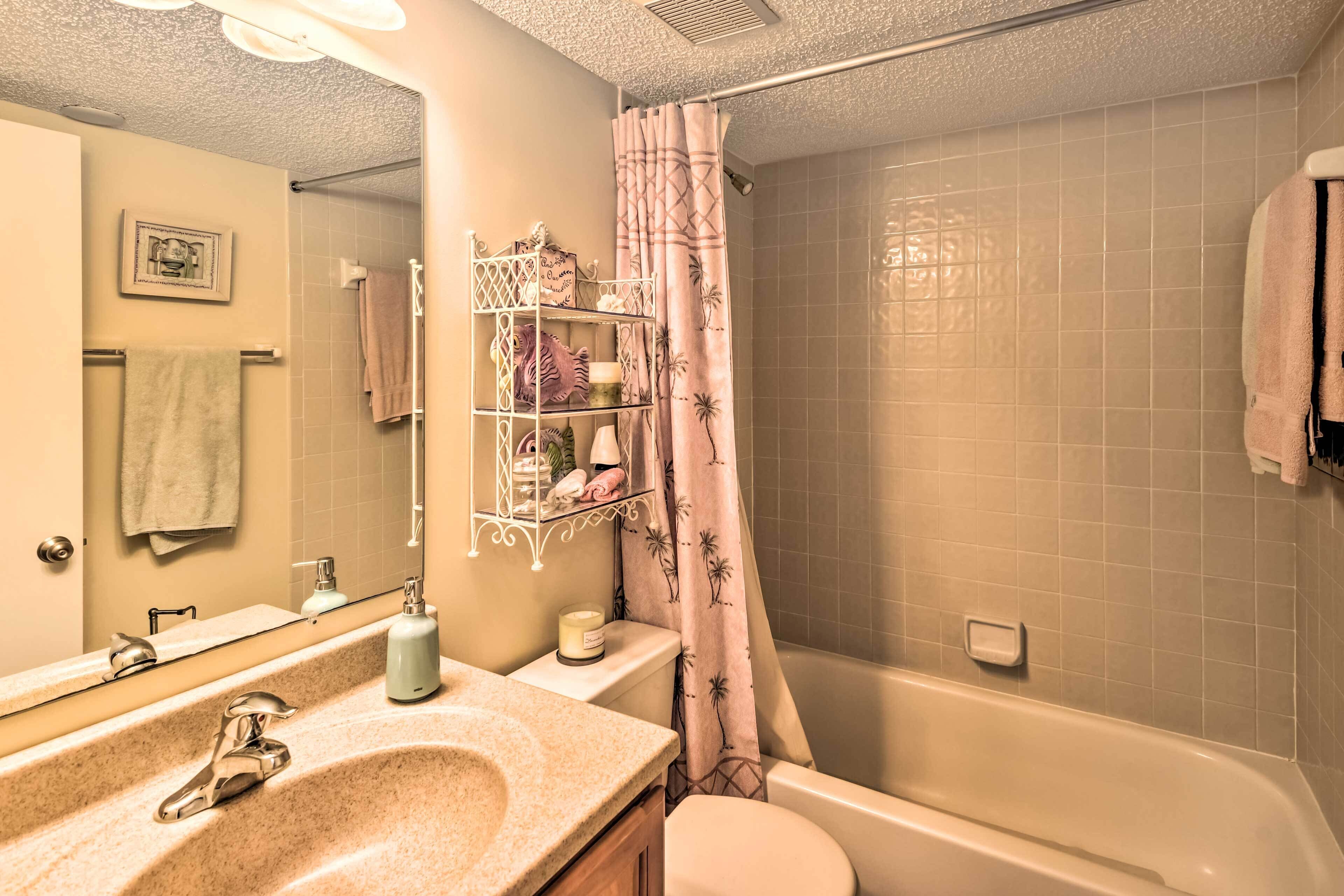 Un baño con lavabo, espejo, inodoro y zona de ducha.