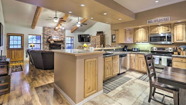 A spacious kitchen with wooden cabinets, a central island, and a 'BED & BREAKFAST' sign. - Pinetop Escape: Charming Mountain Condo w/ Balcony (Pinetop)
