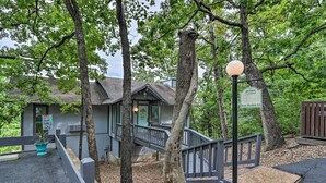 A building with a staircase leading to a porch, surrounded by trees. - < 1 Mi to Lake! Osage Beach Home w/ Furnished Deck (Osage Beach)
