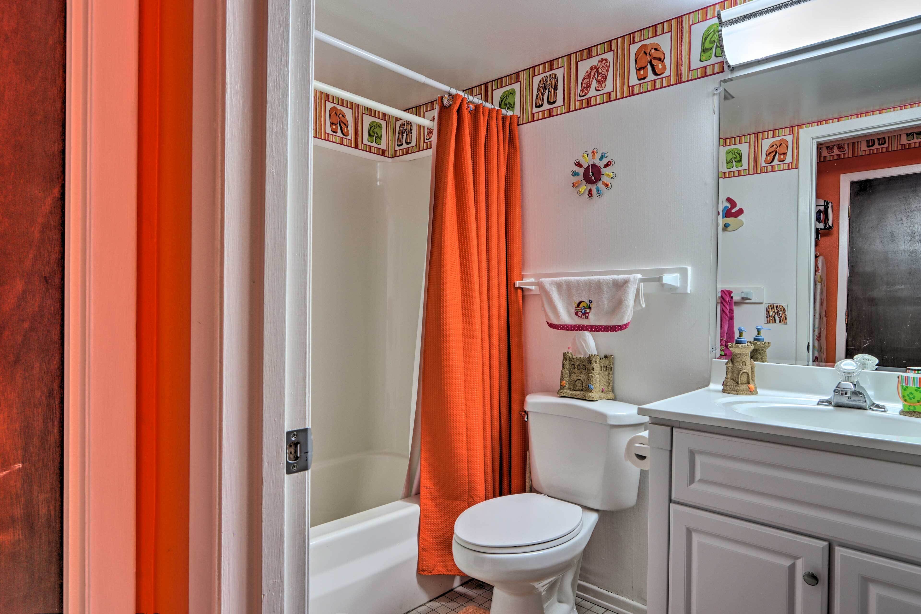 A bathroom with a shower, toilet, and sink.