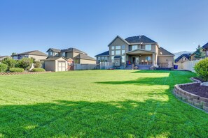 A residential area with houses, a well-maintained lawn, and a clear sky.