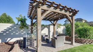 A wooden pergola with outdoor seating, a fire pit, and a well-maintained garden area. - Great Salt Lake House: 5,000 Sq Ft, Mtn Views! (Kaysville)
