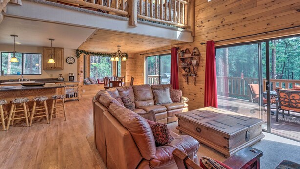 A spacious cabin with a large living area, a kitchen, and a balcony with a view of the forest. - Fish, Hike & Explore: Prescott Cabin w/ Grill! (Prescott)
