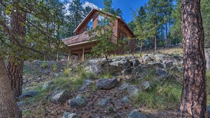 A cabin with a balcony, surrounded by trees and rocks. - Fish, Hike & Explore: Prescott Cabin w/ Grill! (Prescott)